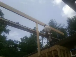 Carpenter setting a ridge beam over a new addition frame — Ice Dam Removal by Roofing Brothers in Hopkins