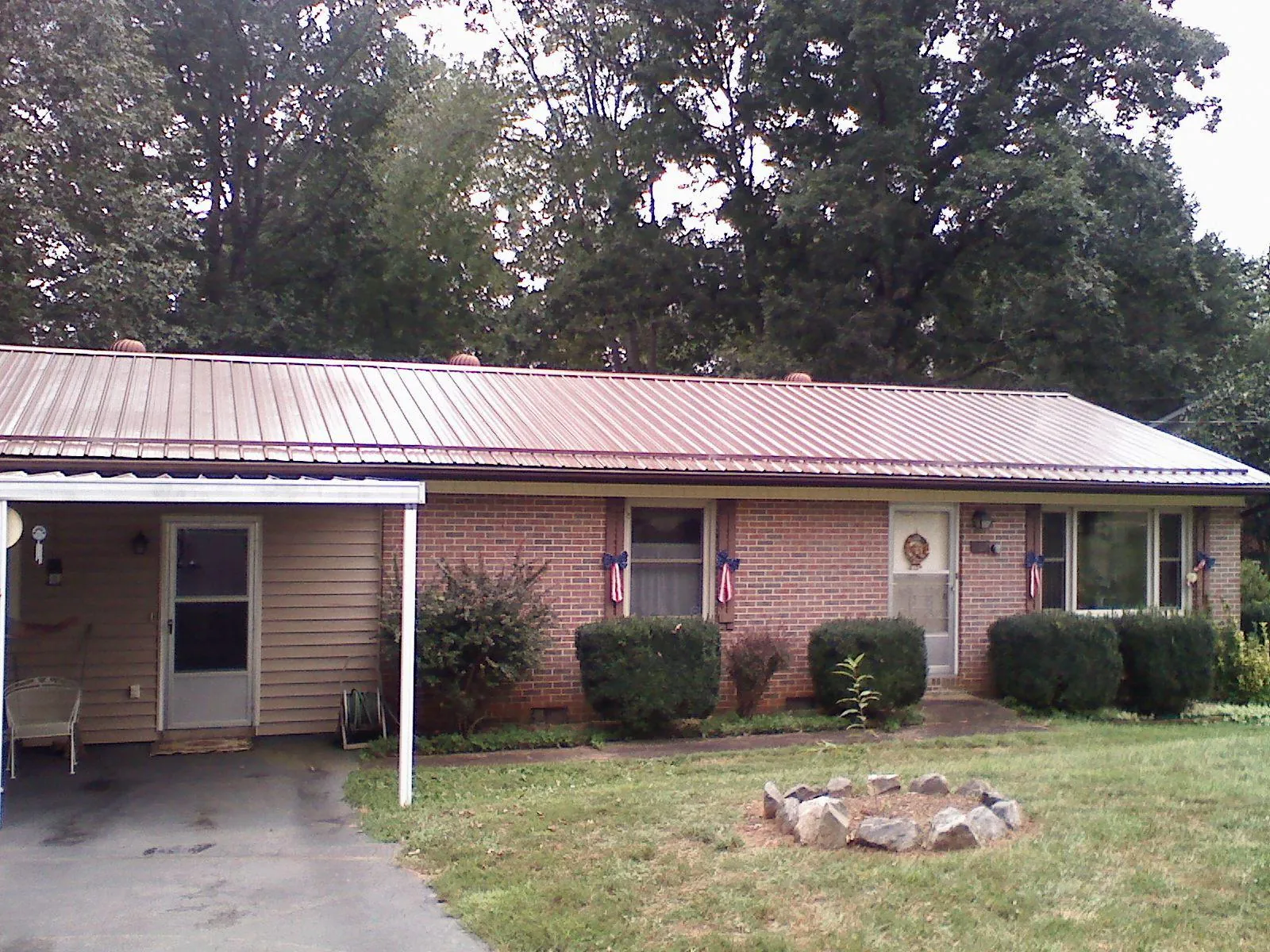 Bronze metal roof and carport on a brick ranch home — Roof Repair work by our crew in Hopkins