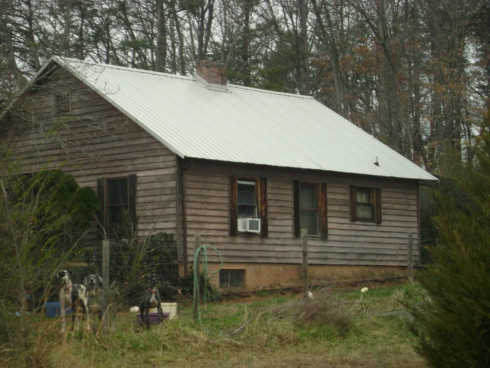 White metal roof on an old wood sided farmhouse, from a Metal Roof Installation job in Hopkins